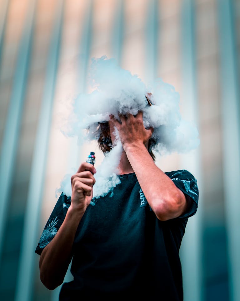 A young man creating vape clouds in an urban setting in Brisbane City, Australia.